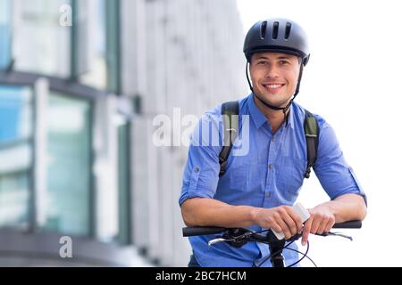 Uomo in bicicletta in città Foto Stock