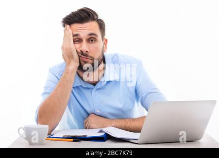 Annoiato giovane uomo alla scrivania Foto Stock