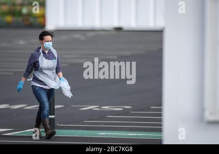 Un tester che indossa dispositivi di protezione individuale (PPE) presso un sito di test del coronavirus vicino all'aeroporto di Manchester, mentre il Regno Unito continua a bloccarsi per contribuire a frenare la diffusione del coronavirus. Foto Stock