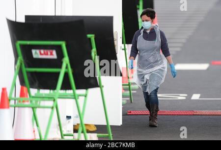 Un tester che indossa dispositivi di protezione individuale (PPE) presso un sito di test del coronavirus vicino all'aeroporto di Manchester, mentre il Regno Unito continua a bloccarsi per contribuire a frenare la diffusione del coronavirus. Foto Stock