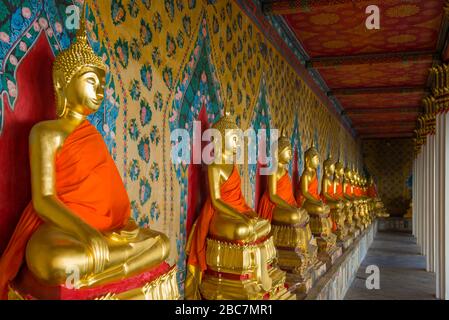 Galleria con vecchie statue di un Buddha seduto nel tempio buddista Wat Arun. Bangkok, Thailandia Foto Stock