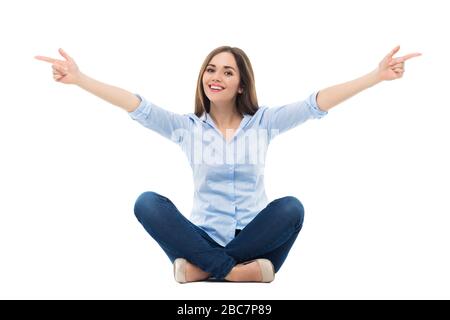Giovane donna seduta su sfondo bianco Foto Stock