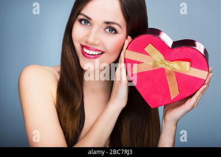 Donna che mantiene heart-shaped box Foto Stock