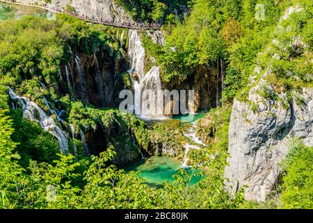 Ammira una serie di cascate di tufo e un passaggio pedonale per i turisti, nel Parco Nazionale dei Laghi di Plitvice, Croazia, Europa. Maggio 2017. Foto Stock