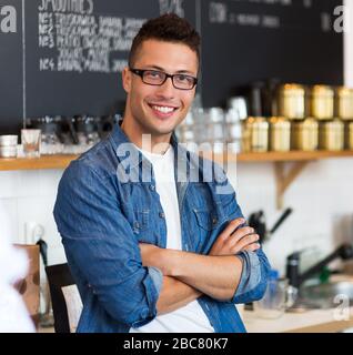 Uomo che lavora nel negozio di caffè Foto Stock