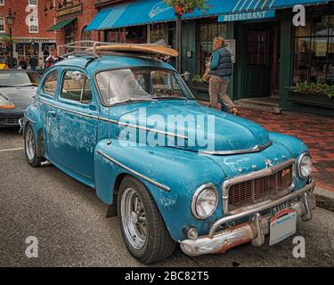 Un Volvo PV544 blu anni '60, indossato dalle intemperie, si parcheggia fuori da un ristorante nello storico porto di Newbury, Massachusetts. Foto Stock