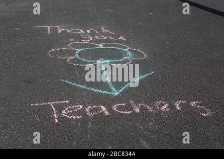 Carmarthen, Regno Unito. 3 aprile 2020. Graffiti di gesso del bambino sul marciapiede dicendo grazie insegnanti come parte di Clap for Carers iniziativa durante Coronavirus pandemic lockdown in Galles, Regno Unito. Credito: Gruffydd Ll. Thomas/Alamy Live News Foto Stock