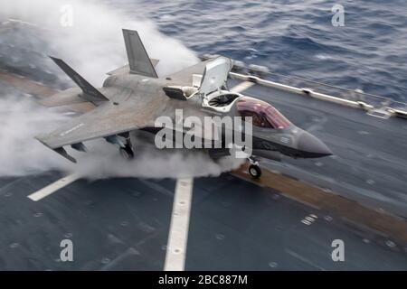 Un combattente furtivo statunitense F-35B Lightning II, assegnato alla 31st Marine Expeditionary Unit, esegue un atterraggio verticale sul ponte di volo della nave d'assalto anfibio di Flagship America USS America durante le operazioni di routine del 28 marzo 2020 nel Mare delle Filippine. Foto Stock