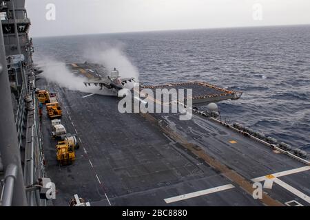 Un combattente furtivo statunitense F-35B Lightning II, assegnato alla 31st Marine Expeditionary Unit, esegue un atterraggio verticale sul ponte di volo della nave d'assalto anfibio di Flagship America USS America durante le operazioni di routine del 28 marzo 2020 nel Mare delle Filippine. Foto Stock