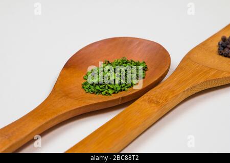 Mestolo di legno con erbe e spezie verdi Foto Stock