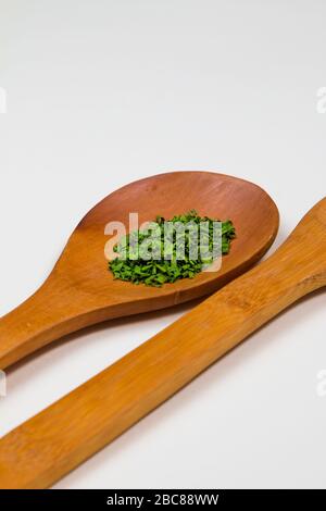 Mestolo di legno con erbe e spezie verdi Foto Stock