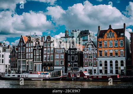Meravigliosa architettura di Amsterdam. Bianchi e soffici nuvole sopra Case pendente Amsterdam, Paesi Bassi. Foto Stock