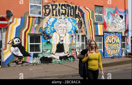 Spettacoli pic: Dato che la Regina è dovuta per l'indirizzo della nazione la Domenica, un murale a Bristol mostra la Regina Òkeeping calmÓ in una posa yoga come gli acquirenti Masked camminare Foto Stock