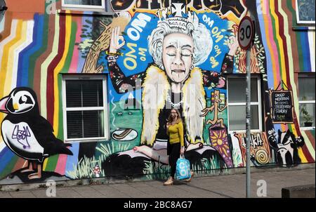 Spettacoli pic: Dato che la Regina è dovuta per l'indirizzo della nazione la Domenica, un murale a Bristol mostra la Regina Òkeeping calmÓ in una posa yoga come gli acquirenti Masked camminare Foto Stock