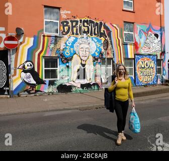 Spettacoli pic: Dato che la Regina è dovuta per l'indirizzo della nazione la Domenica, un murale a Bristol mostra la Regina Òkeeping calmÓ in una posa yoga come gli acquirenti Masked camminare Foto Stock