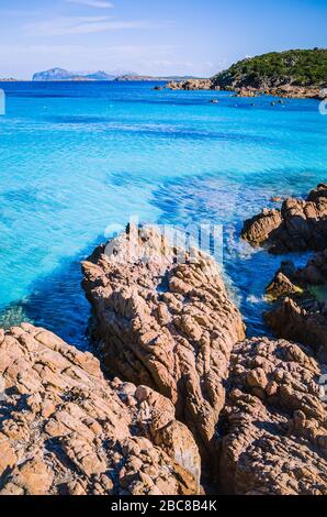 Acqua di mare chiara e colorata con rocce gtanote in Capriccioli, Sardegna, Italia. Foto Stock