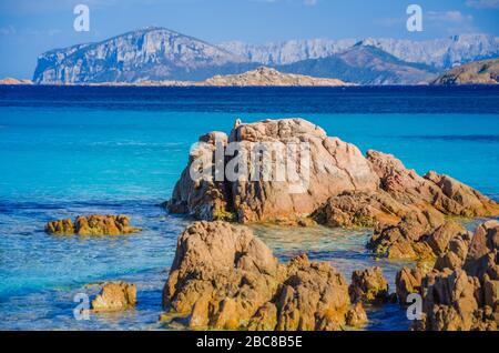 Acqua di mare chiara e colorata e azzurro sulla spiaggia di Capriccioli con rocce granitiche, Sardegna, Italia. Foto Stock