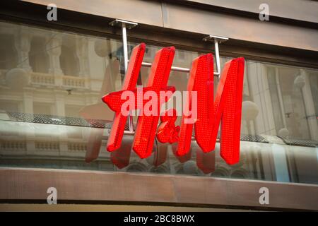 Negozio H&M - marchio britannico di alta moda Street - logo esterno / segnaletica - Londra Foto Stock