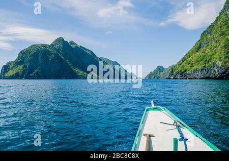 Banca Boat si avvicina all'isola di Mantiloc in Windy Day, El, Nido, Palawan, Filippine Foto Stock