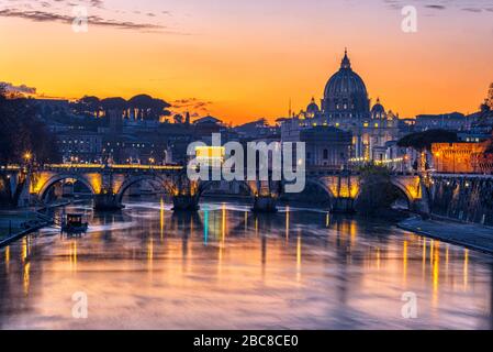 La Basilica di San Pietro nella Città del Vaticano e il Tevere dopo il tramonto Foto Stock