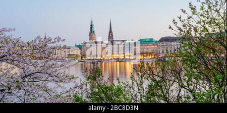 Bellissima vista panoramica del fiume Alster e dal municipio di Amburgo - Rathaus a molla a guadagnare sera durante l ora d'oro. Banner panoramica shot. Foto Stock