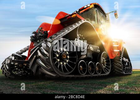 Vista dal basso del trattore agricolo cingolato in gomma. Foto Stock