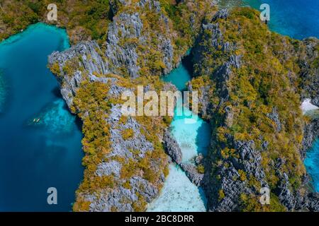 Antenna fuco vista dall'alto in basso di turchese grande e piccola laguna e di pietra calcarea scogliere. Marine riserva nazionale in El Nido, PALAWAN FILIPPINE. Foto Stock