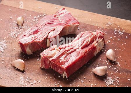 Bistecca di manzo salato su un tavolo di legno Foto Stock