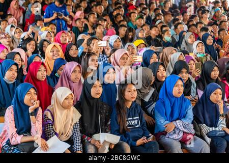 Vista orizzontale di un sacco di studenti musulmani in un pubblico a Bali, Indonesia. Foto Stock