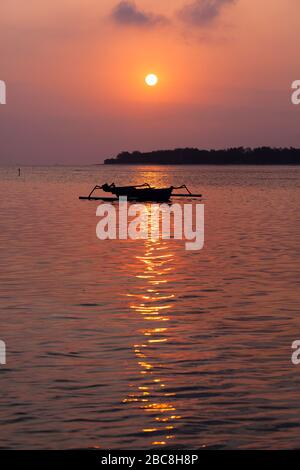 Asia, Indonesia, West Nusa Tenggara, Gili Air, Tramonto su Gili Meno con Barca tradizionale Outrigger Foto Stock