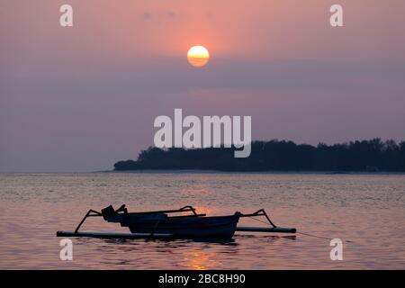 Asia, Indonesia, West Nusa Tenggara, Gili Air, Tramonto su Gili Meno con Barca tradizionale Outrigger Foto Stock