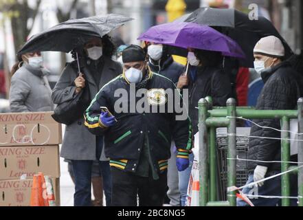 New York, Stati Uniti. 03rd Apr, 2020. Gli acquirenti che indossano maschere facciali protettive aspettano su una linea esterna di entrare in un negozio di alimentari nella sezione Harlem di New York City venerdì 3 aprile 2020. Negli ultimi 3 giorni i decessi per Coronavirus sono raddoppiati fino a quasi 3.000 morti. Foto di John Angelillo/UPI Credit: UPI/Alamy Live News Foto Stock