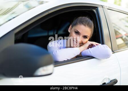 Giovane donna seduta in una macchina Foto Stock