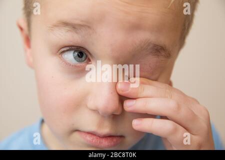 Bambino strofinando gli occhi con le dita Foto Stock