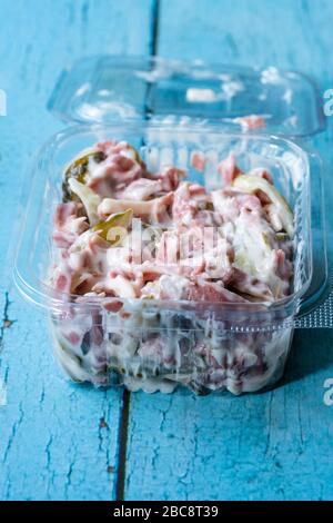 Asporto insalata italiana con maionese, prosciutto e pickle in contenitore di plastica. Piatto tradizionale. Foto Stock