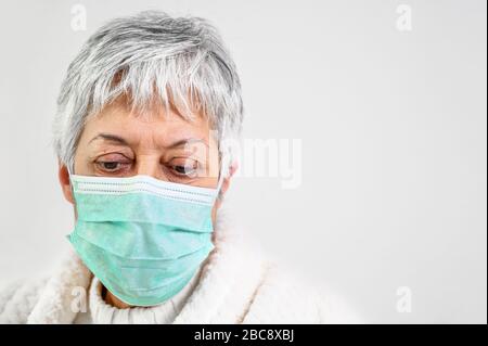 Covid-19. Donna anziana ritratto, indossare maschera di protezione del viso, rischio paziente, protezione contro l'influenza coronavirus e freddo . Foto Stock