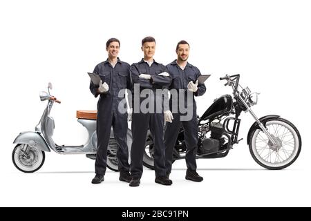Ritratto a tutta lunghezza di meccanici motociclisti in uniforme accanto alle moto isolato su sfondo bianco Foto Stock
