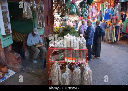 La gente del posto compra i prodotti alimentari da un chiosco in una strada stretta nella medina di Marrakech, Marocco Foto Stock