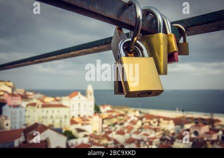 Gruppo di lucchetti d'amore attaccato ad una recinzione sopra la bella vista di Lisbona Foto Stock