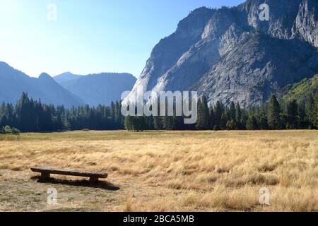 Panca vuota di fronte a El Capitan e un prato giallo nel Parco Nazionale di Yosemite negli Stati Uniti Foto Stock