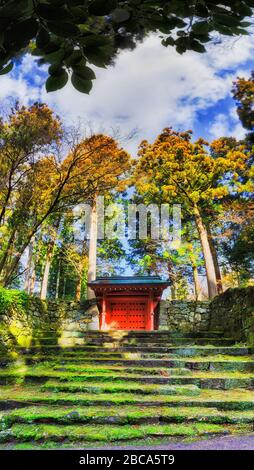 Il cancello rosso in muschio coperto muro di pietra nel villaggio di Ohara, Giappone. Foto Stock