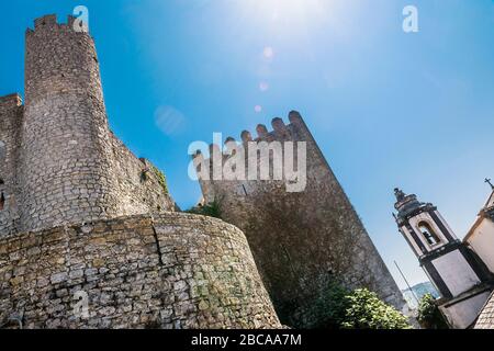 Europa, Portogallo, Estremadura, Centro regione, Obidos, Vila das Rainhas, Città delle Regine, Castelo de Obidos, torre della chiesa, vista ad angolo basso, luce posteriore, s. Foto Stock