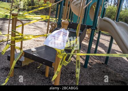 Berks County, Pennsylvania, USA-2 aprile 2020: Parco giochi pubblico chiuso con nastro di attenzione in modo che i bambini non giocano sulle attrezzature per prevenire la diffusione di co Foto Stock