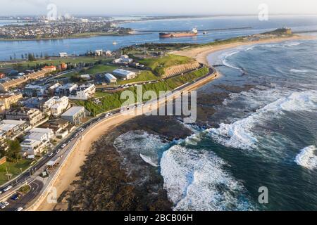 Vista aerea di Nobbys Beach - Fort Scratclhley con nave da carbone che entra nel porto di Newcastle. Newcastle NSW Australia Foto Stock