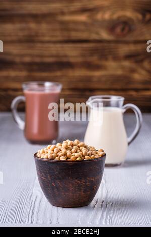 Semi di soia e tazza di cacao e piccola crema su tavolo di legno Foto Stock