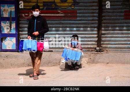 3 aprile 2020: Peshawar, Pakistan. 03 marzo 2020. La gente cammina in una strada lungo un mercato chiuso sorvegliato da ufficiali di polizia nella città settentrionale pakistana di Peshawar. I mercati rimangono chiusi a Peshawar come parte delle misure precauzionali per evitare la diffusione di Covid-19 nel paese Credit: Hasnain Ali/IMAGESLIVE/ZUMA Wire/Alamy Live News Foto Stock