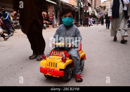 3 aprile 2020: Peshawar, Pakistan. 03 marzo 2020. La gente cammina in una strada lungo un mercato chiuso sorvegliato da ufficiali di polizia nella città settentrionale pakistana di Peshawar. I mercati rimangono chiusi a Peshawar come parte delle misure precauzionali per evitare la diffusione di Covid-19 nel paese Credit: Hasnain Ali/IMAGESLIVE/ZUMA Wire/Alamy Live News Foto Stock