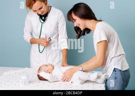 Madre giovane con bambino all'esame di un pediatra Foto Stock