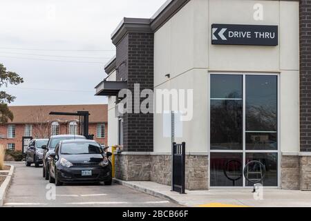 Veicoli in drive-thru presso un punto vendita Starbucks Coffee che utilizzano il servizio di prelievo drive-thru solo a causa della Pandemia COVID-19 in corso. Foto Stock