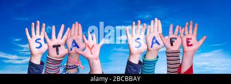 I bambini hanno le mani in mano e la parola rimangono al sicuro, cielo blu Foto Stock